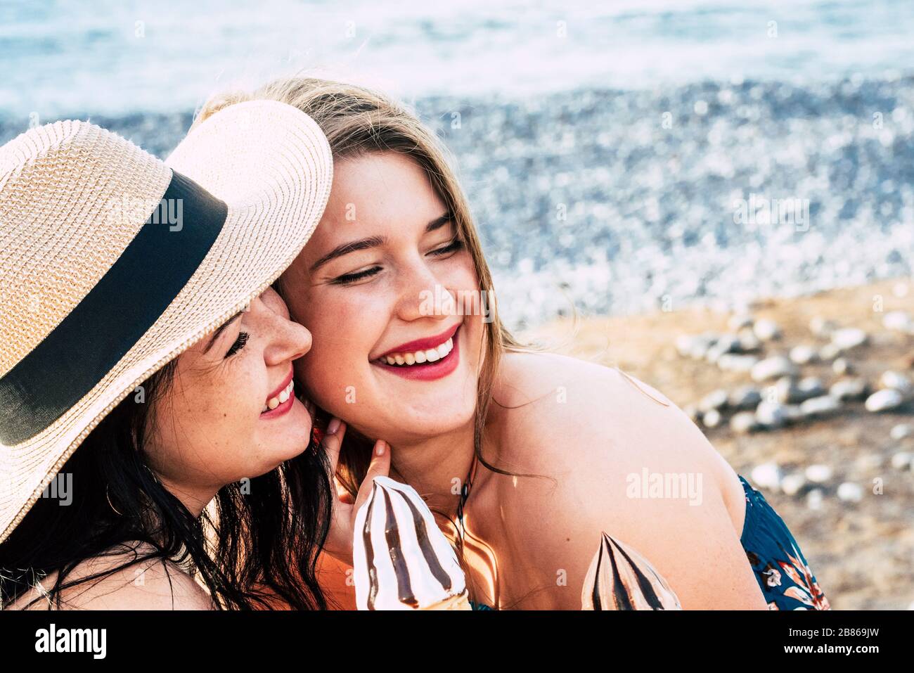Ein paar junge kaukasische Frauen Freunde bleiben in der Freizeit im Freien mit Eis zusammen - Konzept von Sommermenschen, die Freundschaft und Alt genießen Stockfoto