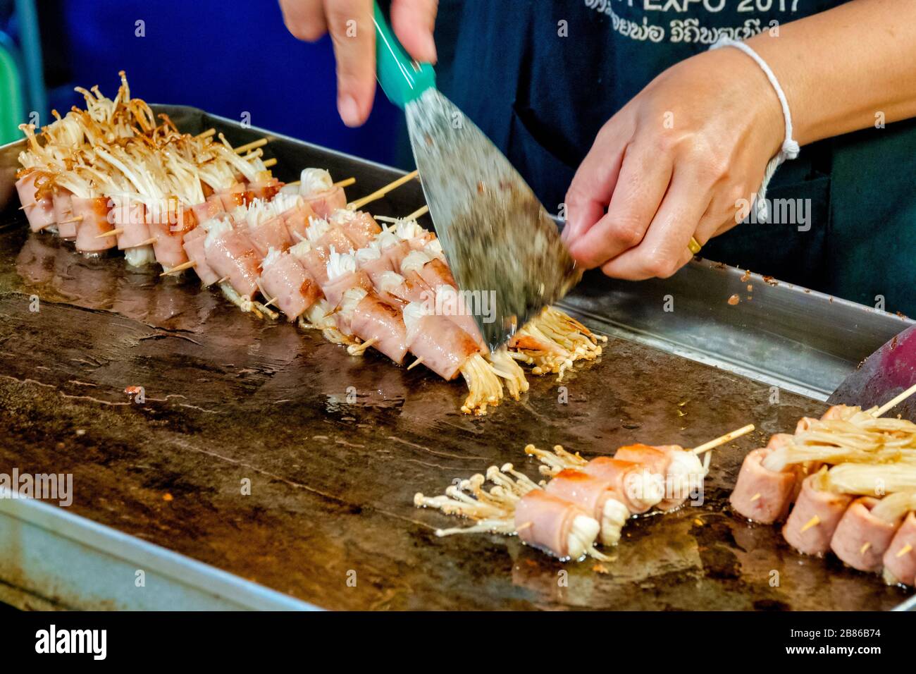 Gebratene Bacon-Wrapped Enoki-Pilze auf einem Spieß, ein gängiges Straßennahrungsmittel in Thailand Stockfoto