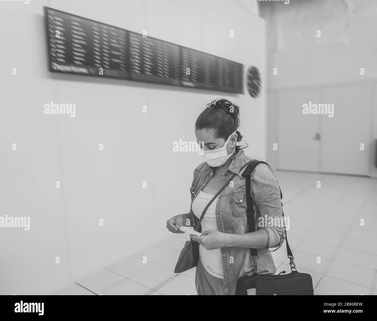 Reisebeschränkungen für Coronavirus Outbreak. Reisende mit Gesichtsmaske am internationalen Flughafen, die von Flugausfällen und Reiseverboten betroffen sind. COVID-19 Stockfoto