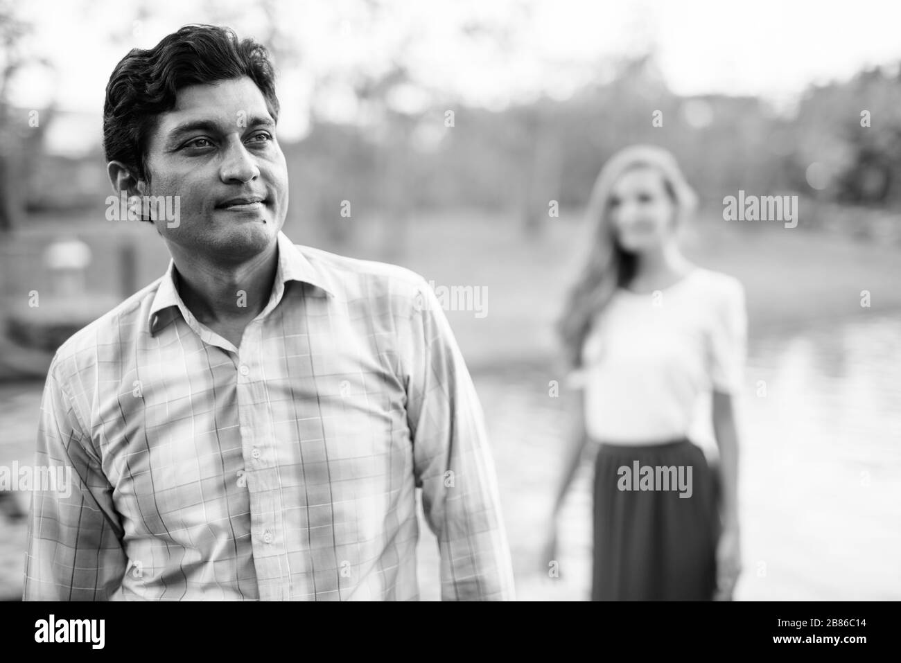 Der indische Mann denkt mit einer schönen Frau, die auf einem Steinpfad mitten im See im Park steht Stockfoto