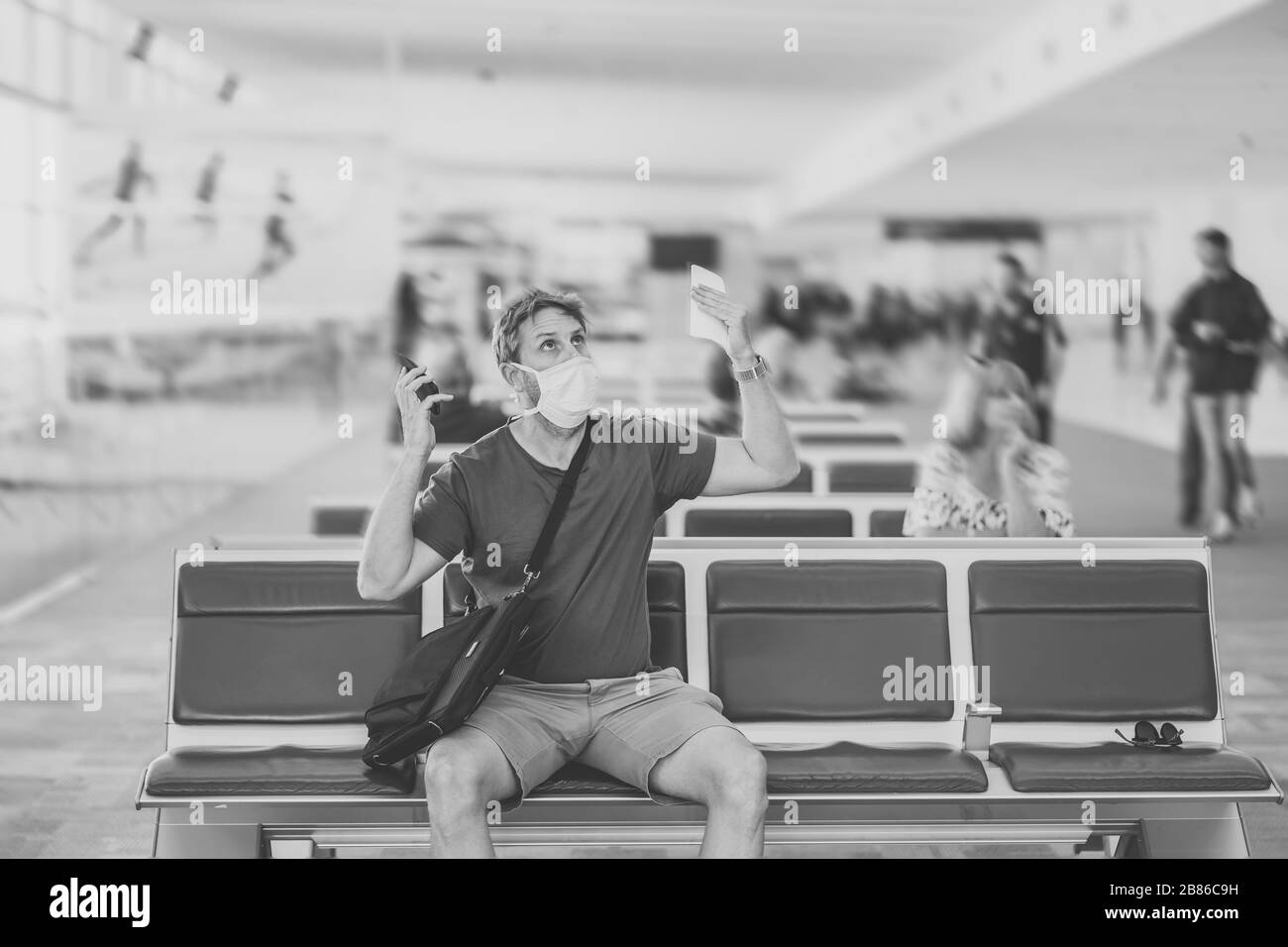 Reisebeschränkungen für Coronavirus Outbreak. Reisende mit Gesichtsmaske am internationalen Flughafen, die von Flugausfällen und Reiseverboten betroffen sind. COVID-19 Stockfoto