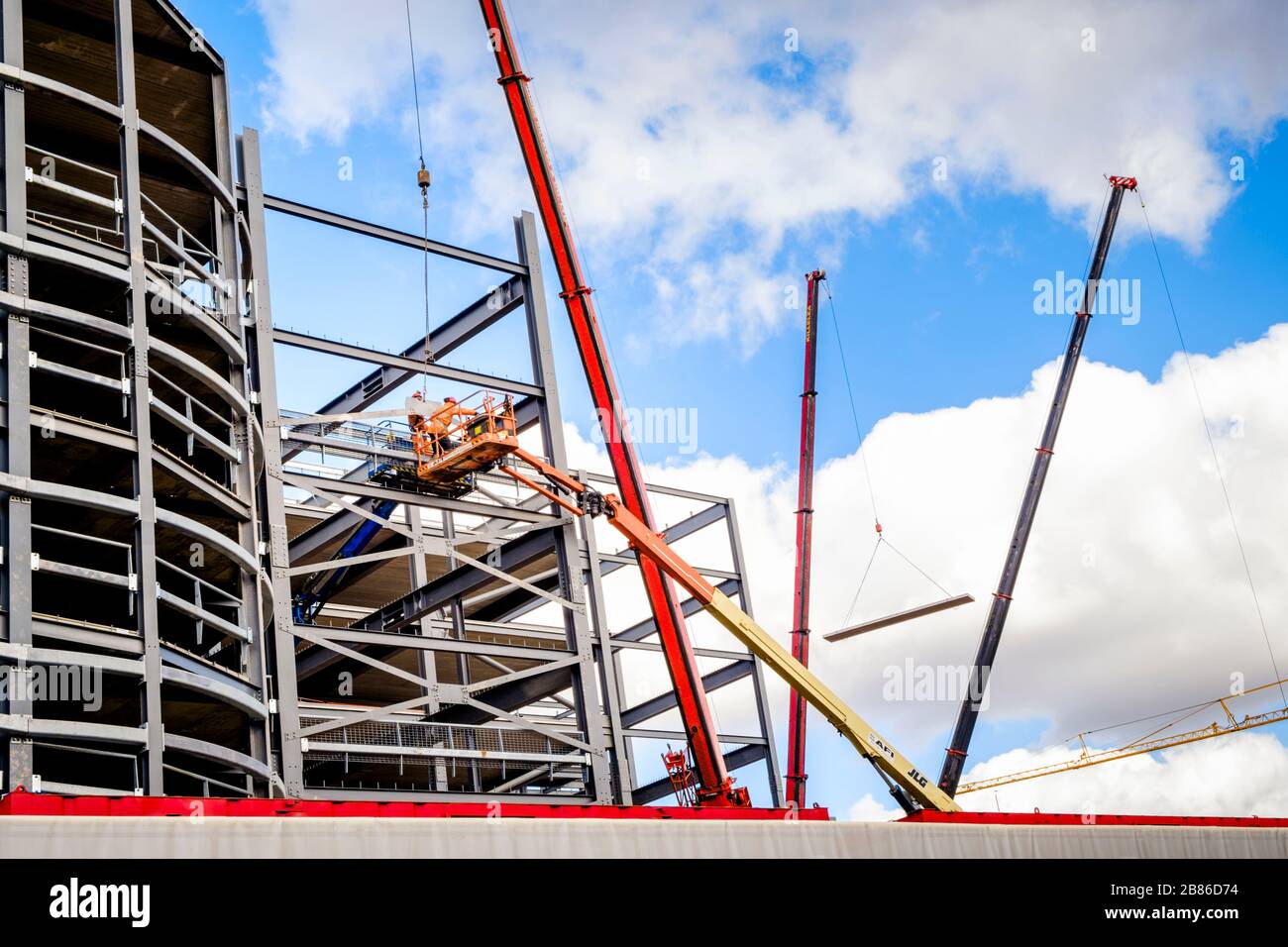 Kräne und Kirschpflücker beim Bau eines Neubaus mit Stahlfachwerkkonstruktion im Einsatz. Nottingham, England, Großbritannien Stockfoto