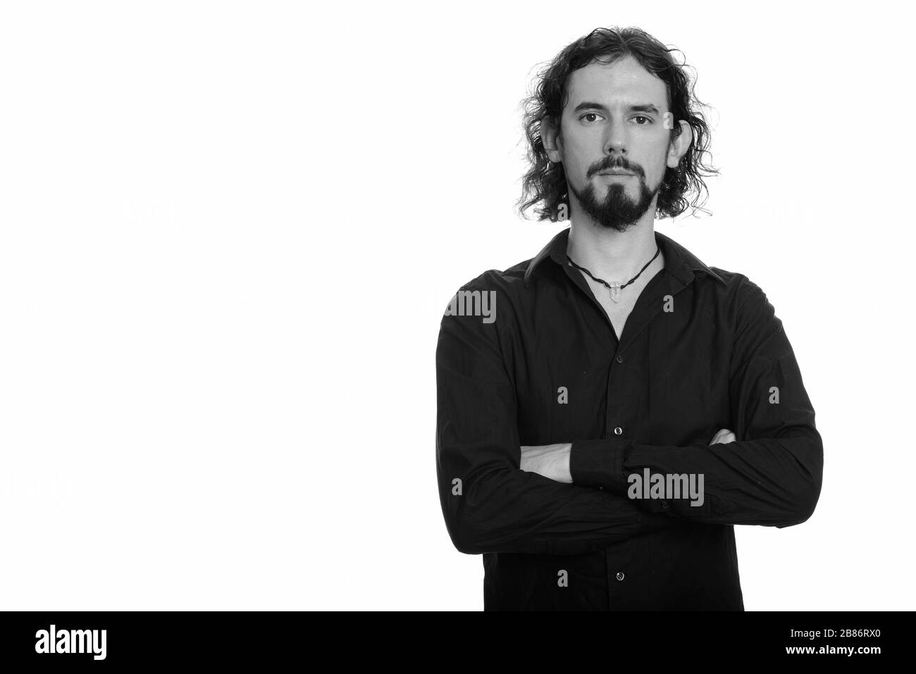 Porträt eines hübschen bärtigen Geschäftsmannes mit gekreuzten Armen Stockfoto