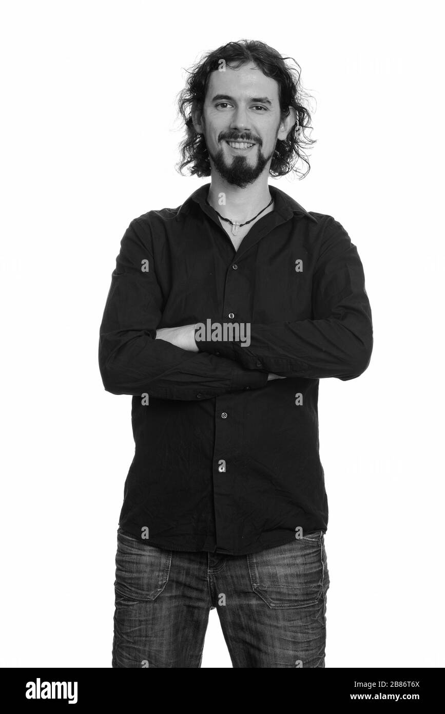 Porträt eines glücklichen, gutaussehenden bärtigen Geschäftsmannes, der mit gekreuzten Armen lächelte Stockfoto