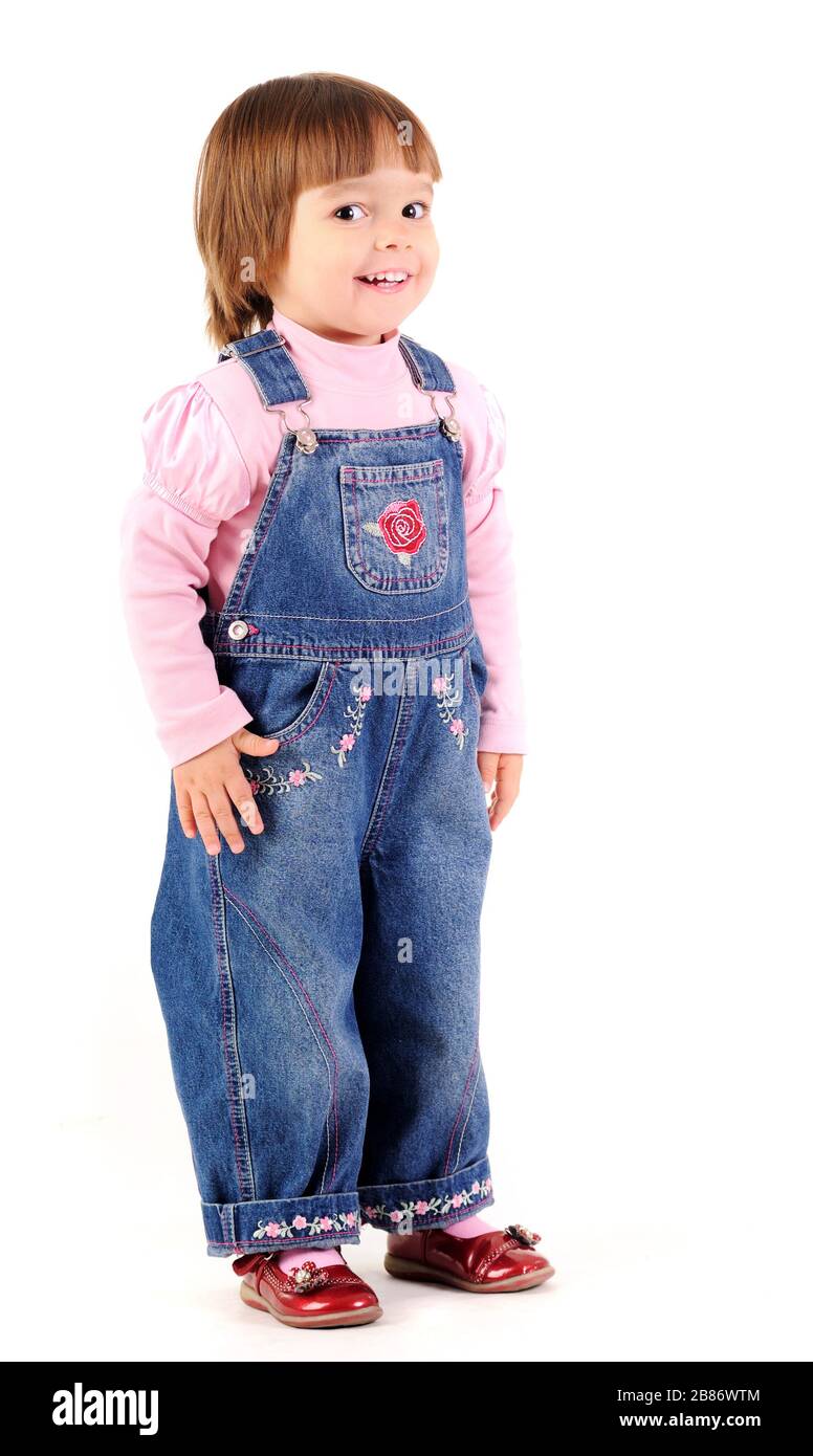 Kleines Mädchen in Jeans Jumpsuit beim gehen und Lächeln über weißem  Hintergrund im Fotostudio. Schönes Lifestyle-Konzept für glückliche Kinder  Stockfotografie - Alamy