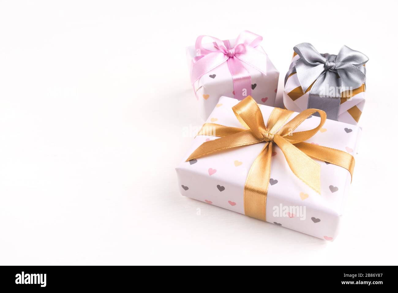 Drei Geschenkschachteln mit Bögen auf weißem Hintergrund. Stockfoto