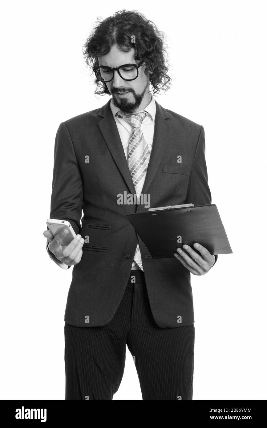 Stattlichen kaukasischen Geschäftsmann holding Zwischenablage und Mobiltelefon Stockfoto