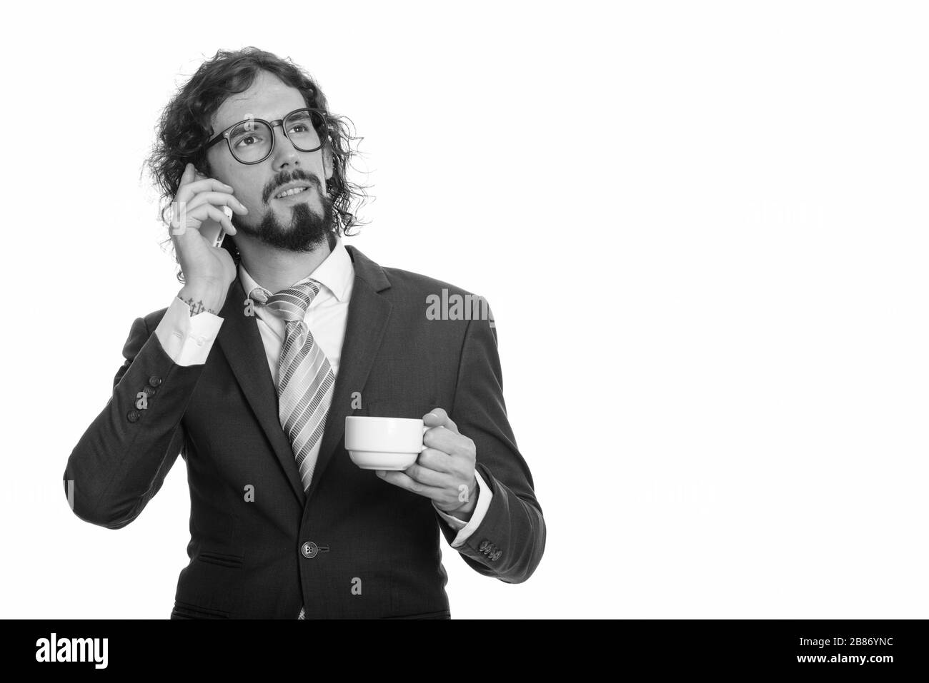 Stattlichen kaukasischen Geschäftsmann Gespräch am Handy und halten Kaffee Tasse beim Denken Stockfoto