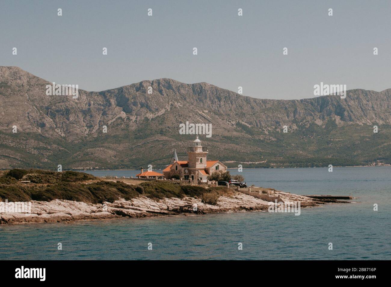 Großes Haus auf der Insel mit Bergen im Hintergrund Stockfoto