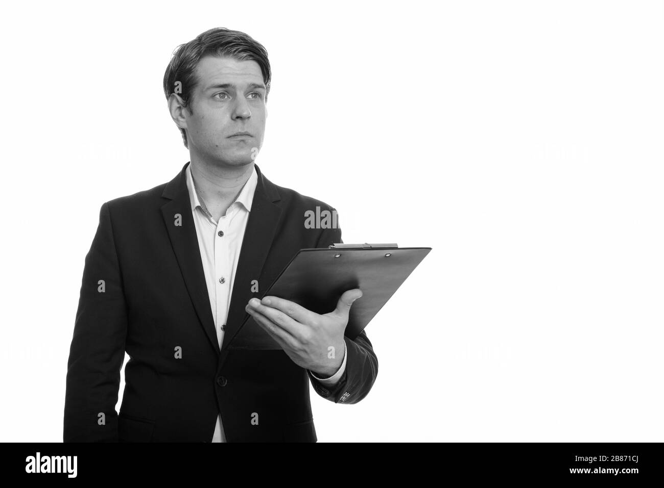 Stattlichen kaukasischen Geschäftsmann holding Zwischenablage beim Denken Stockfoto