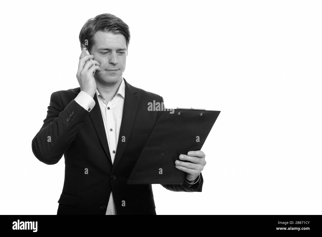 Stattlichen kaukasischen Geschäftsmann lesen Zwischenablage beim Gespräch am Handy Stockfoto