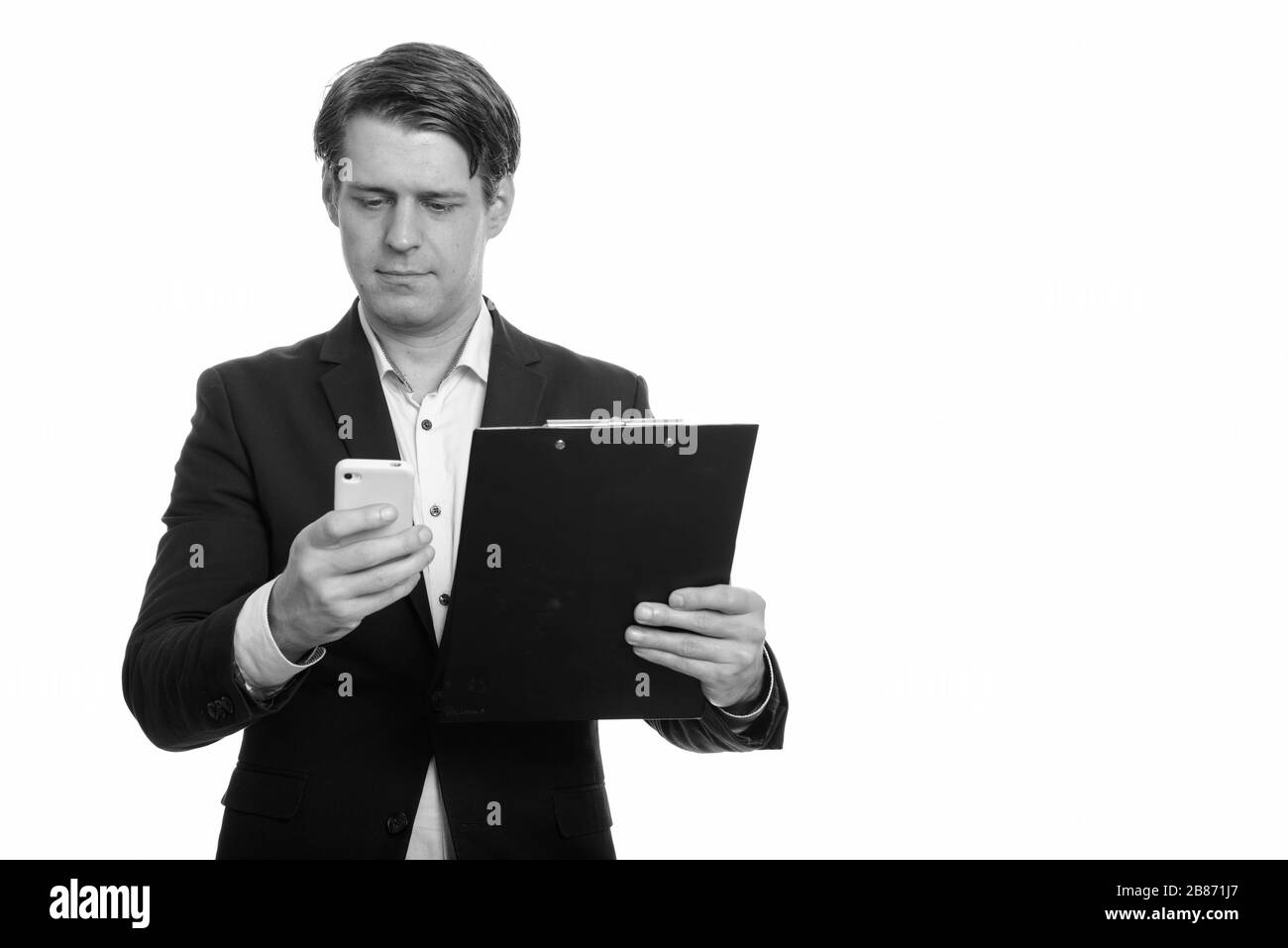 Stattlichen kaukasischen Geschäftsmann mit Mobiltelefon, während Sie die Zwischenablage Stockfoto