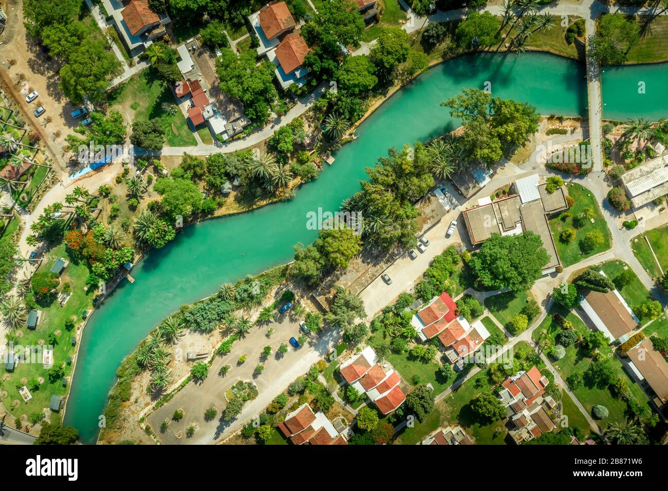 Luftpanorama des türkisfarbenen Flusses Amal, der durch die traditionell in der Landwirtschaft ansässige Kollektivgemeinde Kibbutz NIR David in Israel verläuft Stockfoto