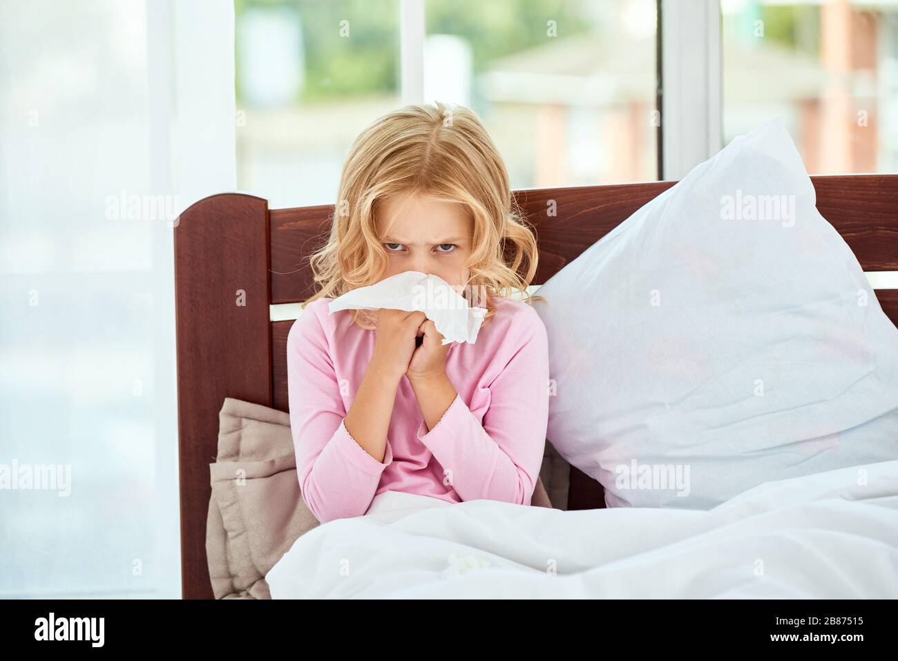 Kleines Mädchen mit runniger Nase, das an Kälte oder Grippe leidet, während es zu Hause im Bett liegt. Viruserkrankung. Coronavirus Konzept. Konzept für das Gesundheitswesen Stockfoto