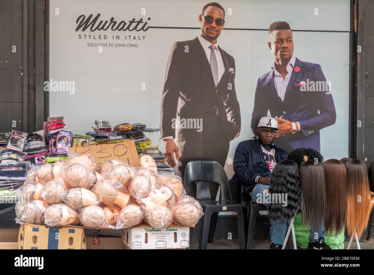 Pretoria, Südafrika - 24. Mai 2019: Straßenhändler verkauft gefälschte Haare vor dem stilvollen italienischen Modegeschäft Stockfoto
