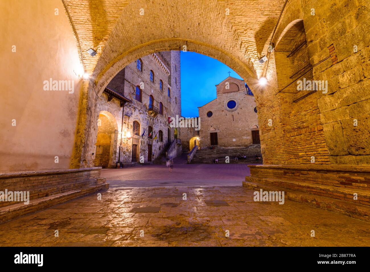 San Gimignano, Toskana: Palazzo Comunale, Torre Grossa und Duomo, eingerahmt von einem Bogen des Palazzo Vecchio del Podestà auf der Piazza del Duomo. Stockfoto