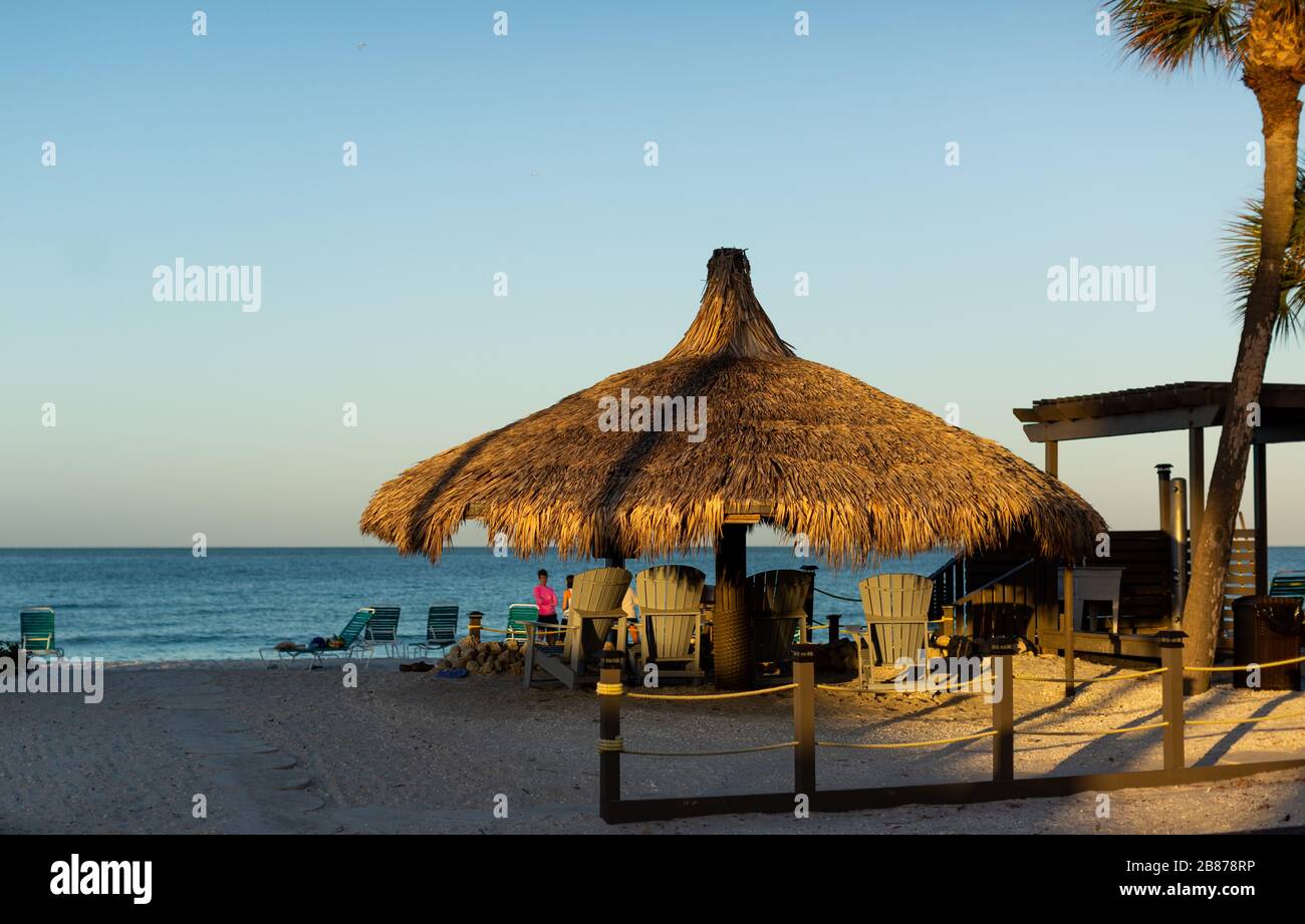 Lido Beach, Florida, USA - 20. März 2020. Palmenhütten werden am frühen Morgen hell ersonnen, wenn die Sonne über den Golf von Mexiko aufgeht. Stockfoto
