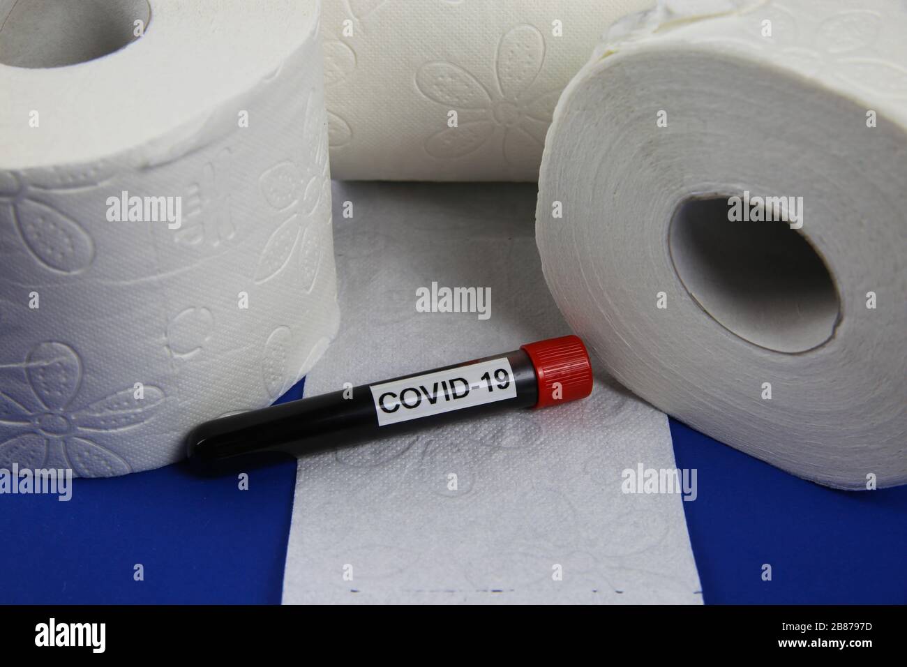 Rätsel um Stock-Objekte und Panikkauf im Corona-Virus-Krisenkonzept: Isolierte weiße toilettenpapierrollen mit Kovid-19-Blut-Durchstechflasche Stockfoto