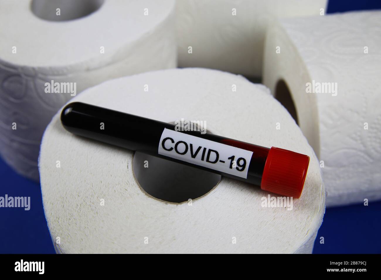 Rätsel um Stock-Objekte und Panikkauf im Corona-Virus-Krisenkonzept: Isolierte weiße toilettenpapierrollen mit Kovid-19-Blut-Durchstechflasche Stockfoto