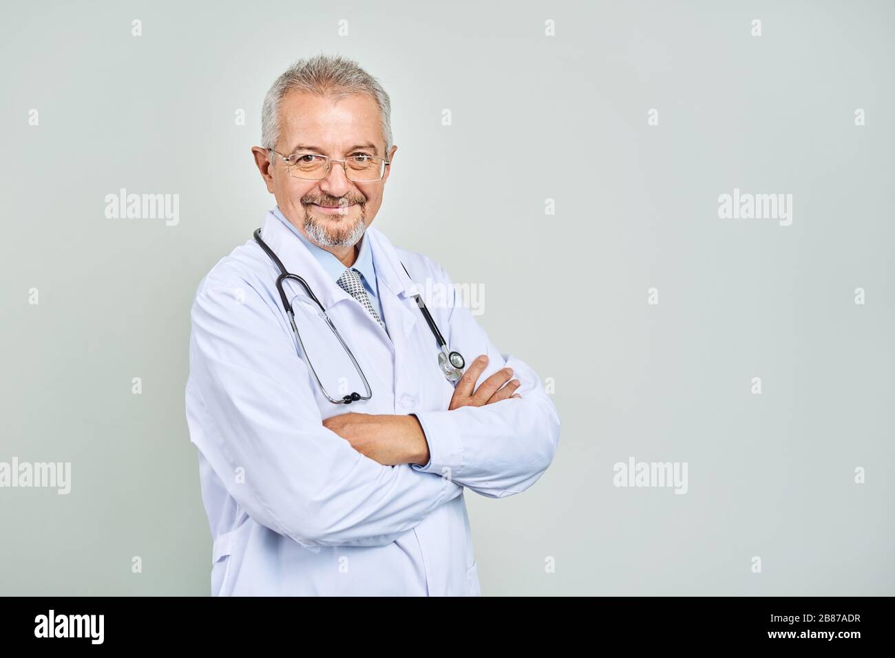 Fröhliche reife Arzt posing und lächelnd an Kamera, Gesundheitswesen und Medizin. Stockfoto