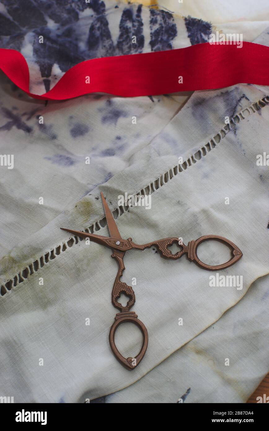 Mehrere Paar alte Nähscheren und eine Spule mit rotem Band Stockfoto