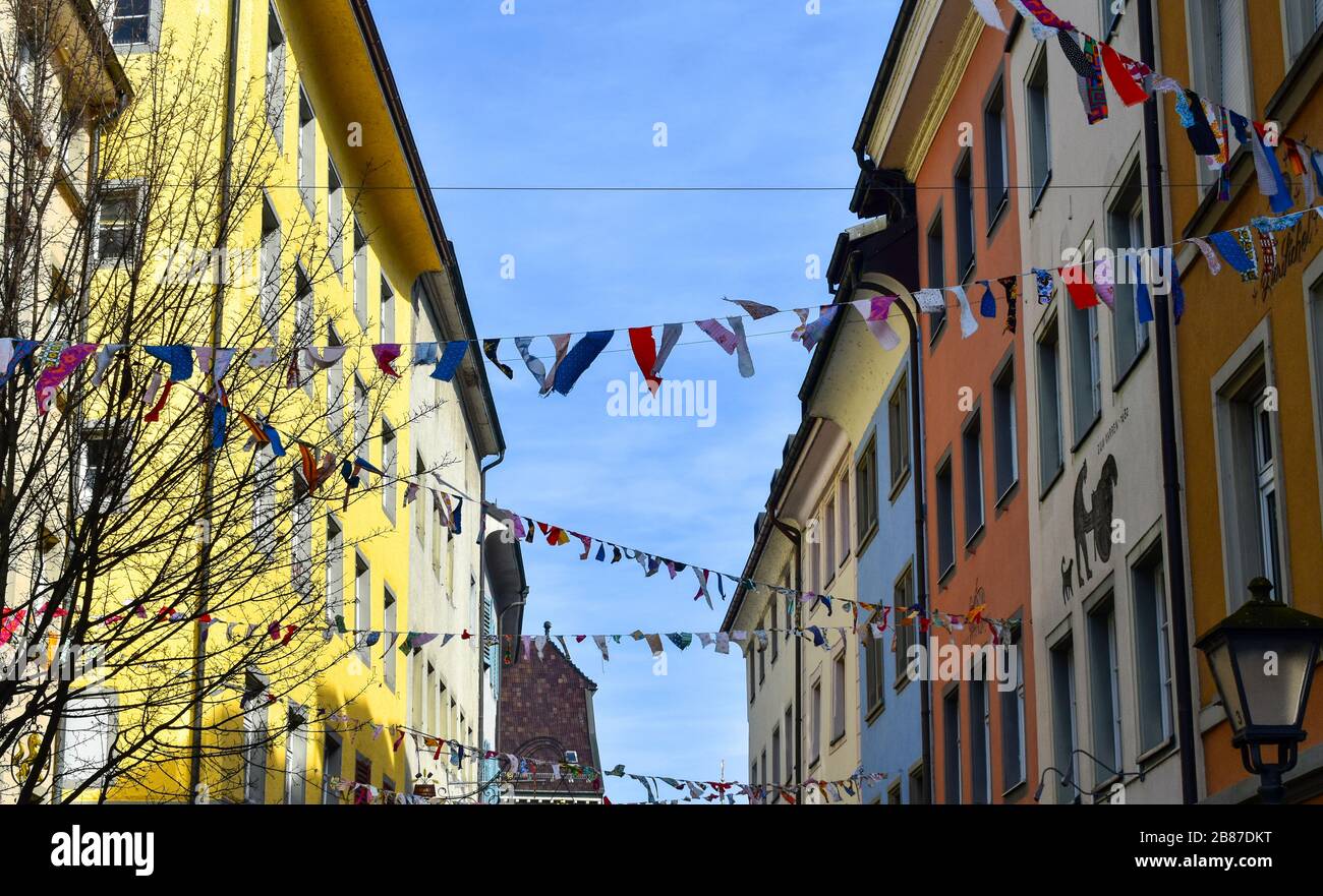 Konstanz, Deutschland - 15. Februar 2020: Verzierte Straßen mit bunten Flaggen in Karnevalszeit. Überfüllte Straßen der Stadt während des Fastnachts-Karnevals. Stockfoto