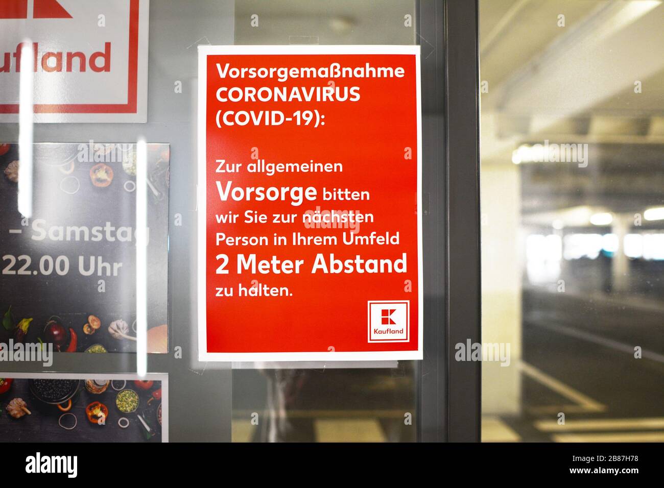 Rotes Informationsschild am Eingang des deutschen Lebensmittelgeschäfts informiert Kunden über Regeln, die 2 Meter Abstand zu anderen Kunden halten Stockfoto