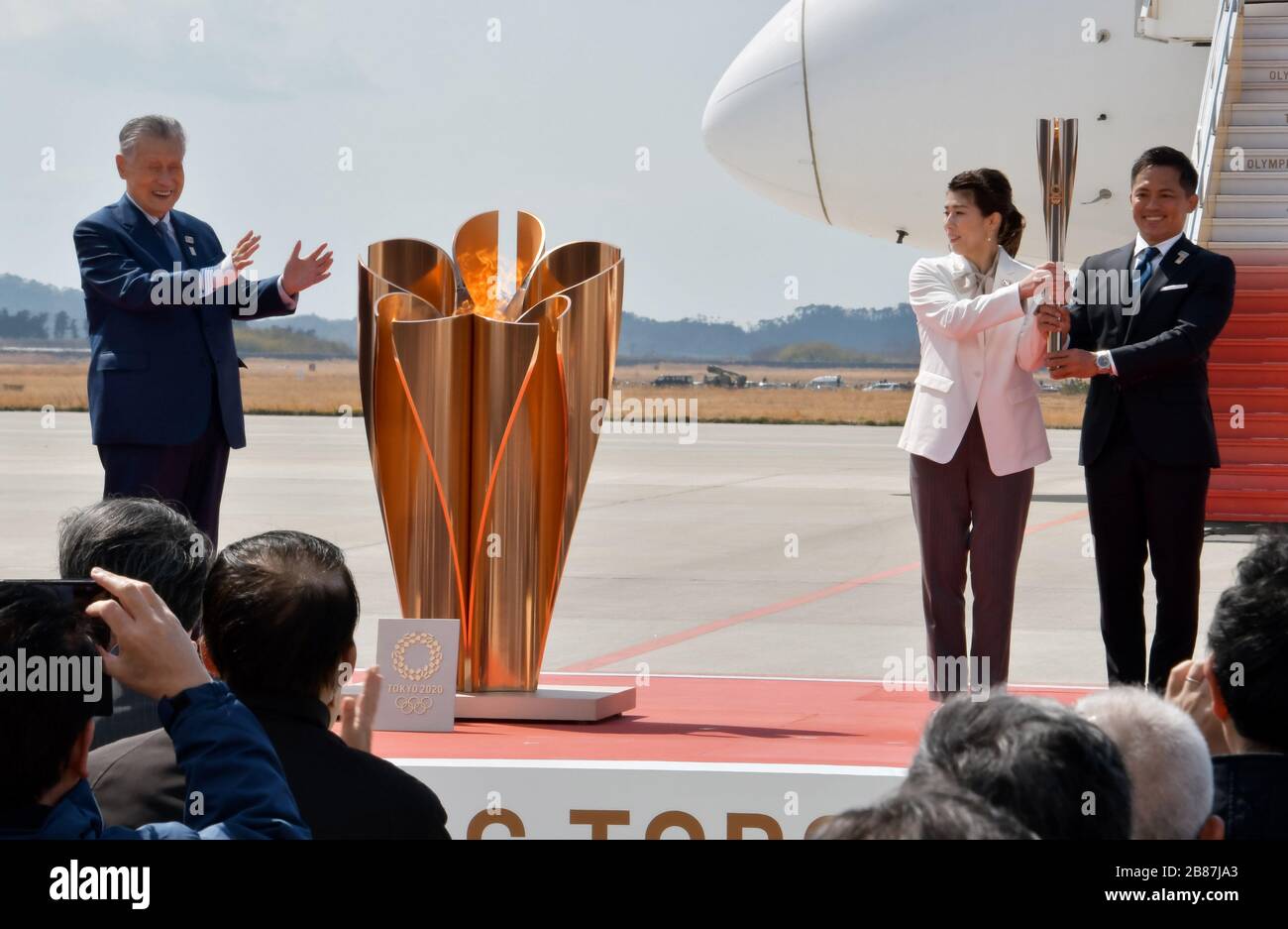 Die dreifachen olympischen Goldmedaillengewinner Tadahiro Nomura(R) und Saori Yoshida(C) tragen die olympische Fackel während der olympischen Flammenantrittveranstaltung in der Japan Air Self-Defence Force (JASDF) Matsushima Base in Higashi-Matsushima, Präfektur Miyagi, Japan am Freitag, 20. März 2020. Foto von Keizo Mori/UPI Stockfoto