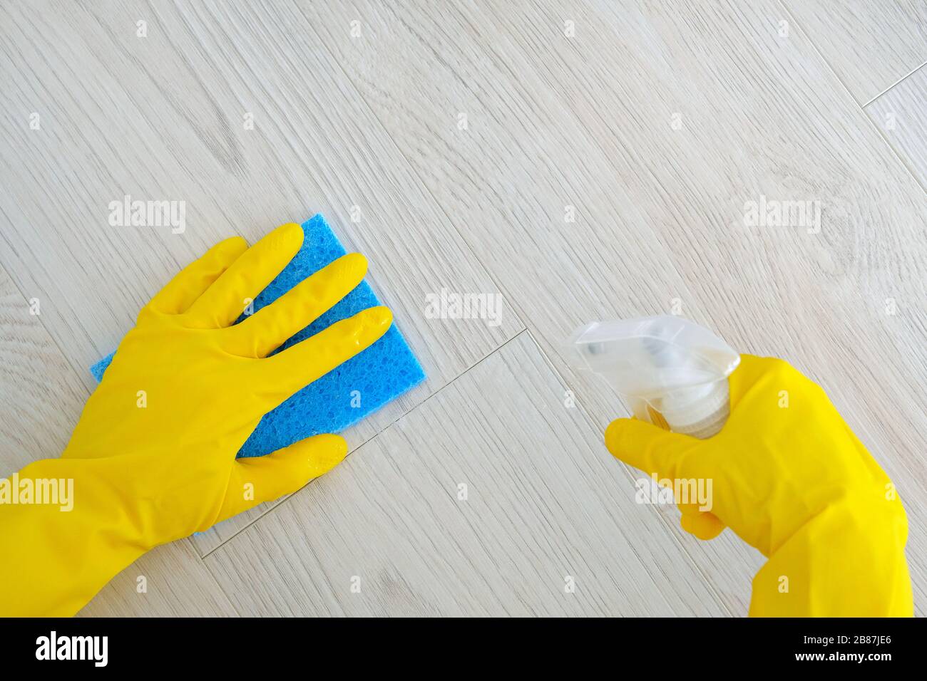 Hand in gelben Gummischutzhandschuh mit Mikrofasertuch und Waschmittel in Spray, Kopierraum. Reinigungszubehör. Draufsicht. Flaches Lay. Stockfoto Hand in gelben Gummischutzhandschuh mit Mikrofasertuch und Waschmittel in Spray, Kopierraum. Reinigungszubehör. Draufsicht. Flaches Lay. Stockfoto