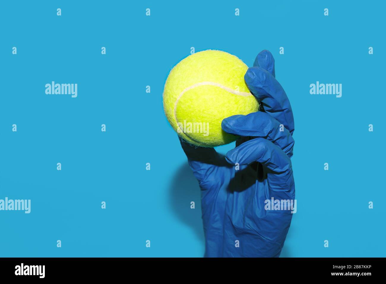 Tennisball in der Hand in medizinischen Handschuhen Stockfoto