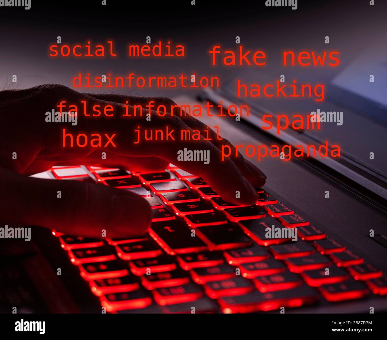 Nahaufnahme der Finger, die im Dunkeln leuchtende rote Tasten der Hintergrundbeleuchtung auf einer Computertastatur eingeben. Glühender roter Text über Computerhacker, gefälschte Nachrichten, Disinf Stockfoto