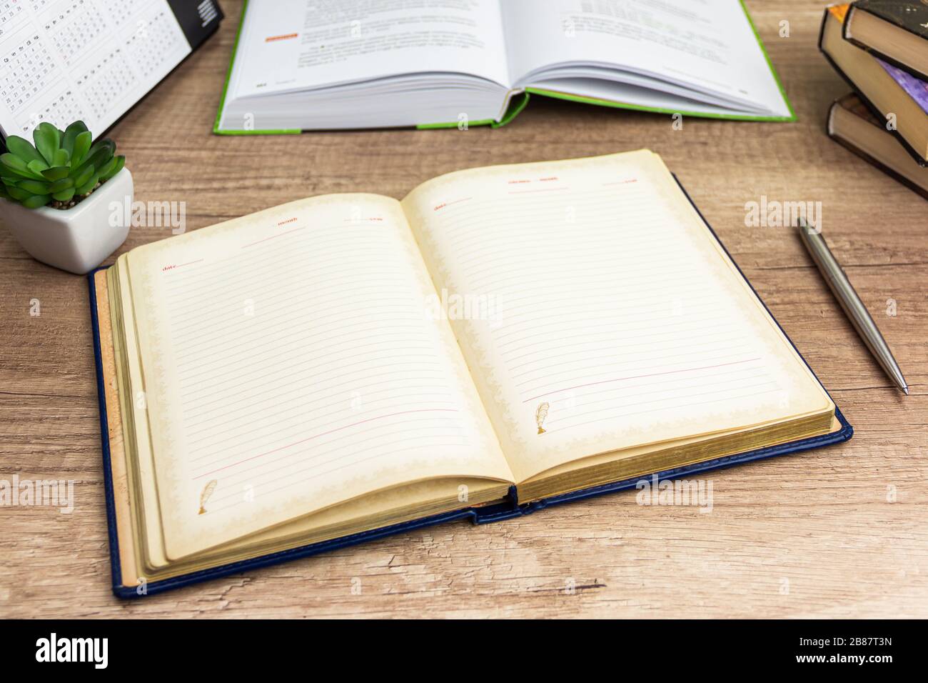 Öffnen Sie das Notebook mit Stift für Ihren Text im Hintergrund. Öffnen Sie das Buch, und Bücher hängen am Arbeitsplatz, der zum Schreiben bereit ist. Stockfoto