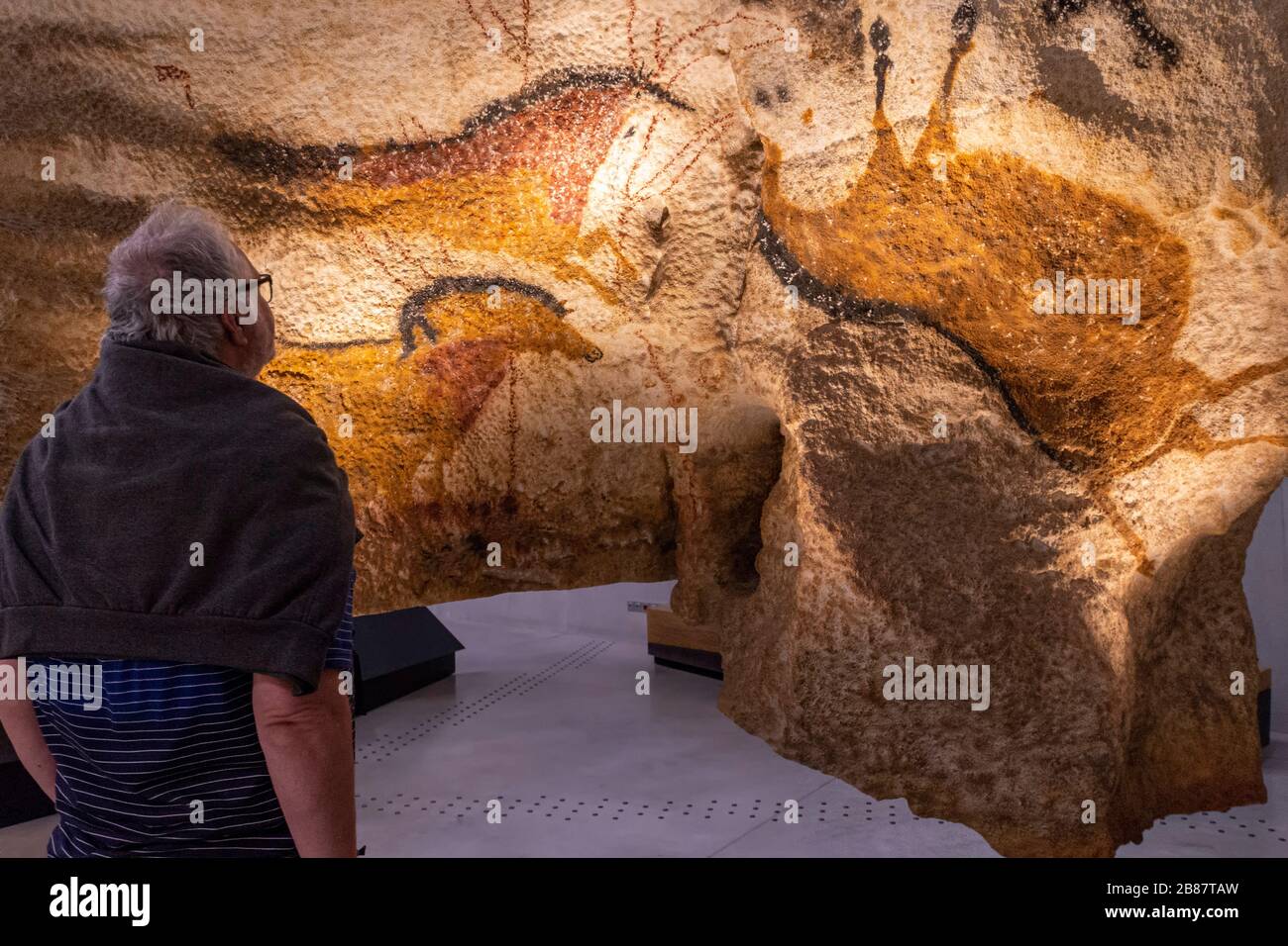 Ein Besucher blickt auf eine Nachbildung eines prähistorischen Höhlenmales im Lascaux Centre in Montignac, Frankreich. Stockfoto