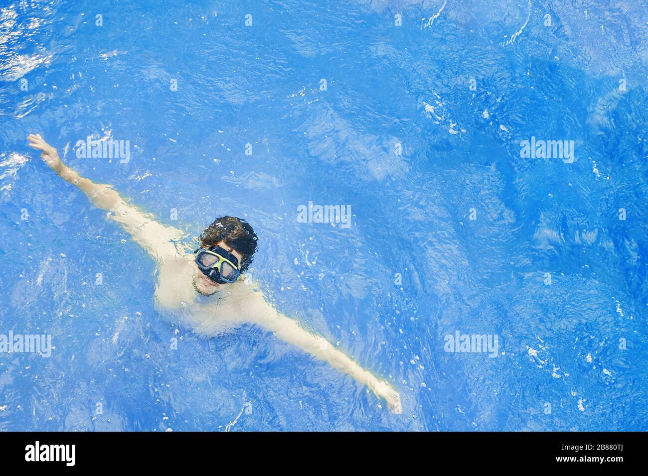 Der Mensch in einer Unterwassermaske tritt aus dem Wasser hervor, im Urlaub taucht er im Ozean. Stockfoto