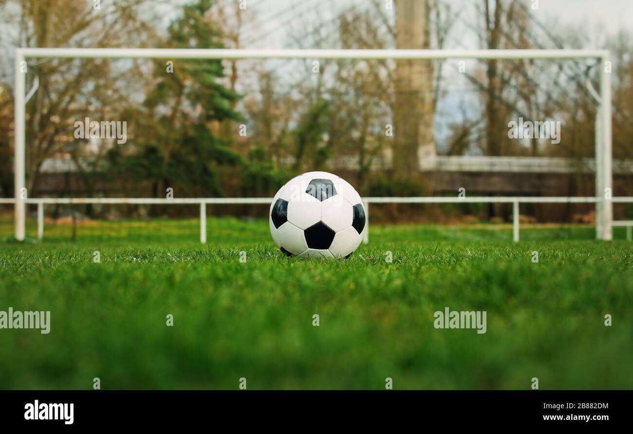 Typischer Fußball auf der Freistoßmarkierungslinie vor dem Stadiontor. Traditioneller Fußball-Ball auf dem grünen Rasen vor dem Tor. Stockfoto