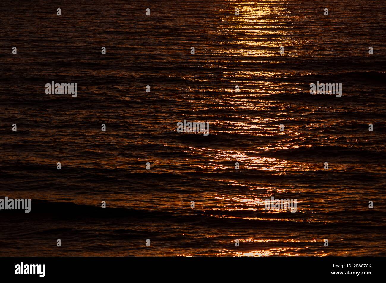 Abgehackenes Meer bei Sonnenuntergang, orange und rot abstrakte Textur Stockfoto