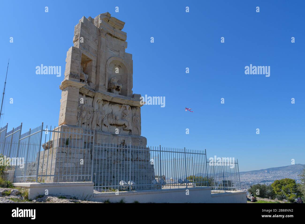 Filopappou Denkmal mit Drachen im Hintergrund am sauberen Montagstag Stockfoto