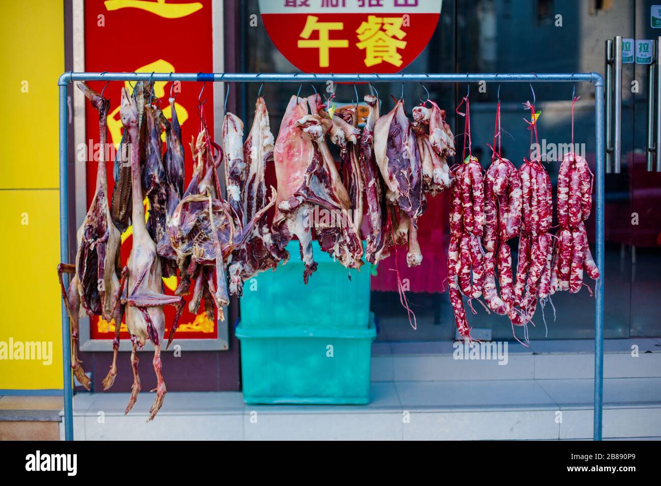 Eine Vielzahl von Tieren entkernt und hängte, um außerhalb einer Metzgerei in einem Hutong in China zu trocknen. Stockfoto