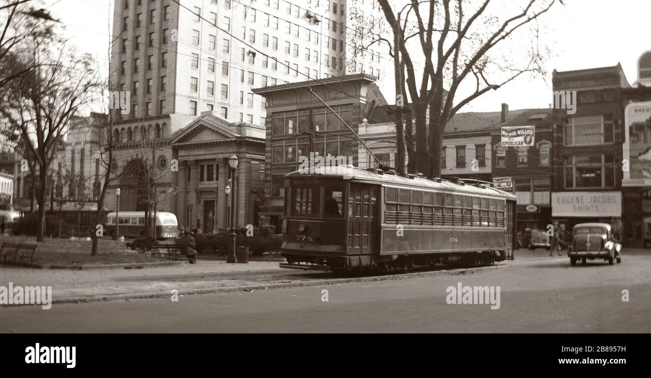 Dies ist ein alter Blick auf Trolley # 774 auf Wilkes Barre, dem Public Square der 40er Jahre von Pennsylvania. Im Hintergrund sieht man Automobile aus dieser Zeit und einen neueren Luzerne County Transportation Bus. Wilkes Barre war zu dieser Zeit noch ein großes Zentrum für den Anthrazitkohlebergbau. Wilkes Barre wurde und wird aufgrund der Tatsache, dass auch Anthrazitkohle als Black Diamonds bezeichnet wurde, als Diamond City bezeichnet. Es gibt noch Elemente, die von Wilkes Barres Kohlebergbau an der Vergangenheit im Wyoming Valley sichtbar sind.auch das Wyoming Valley wurde von der Agnes Flood von 1972 beeinflusst Stockfoto