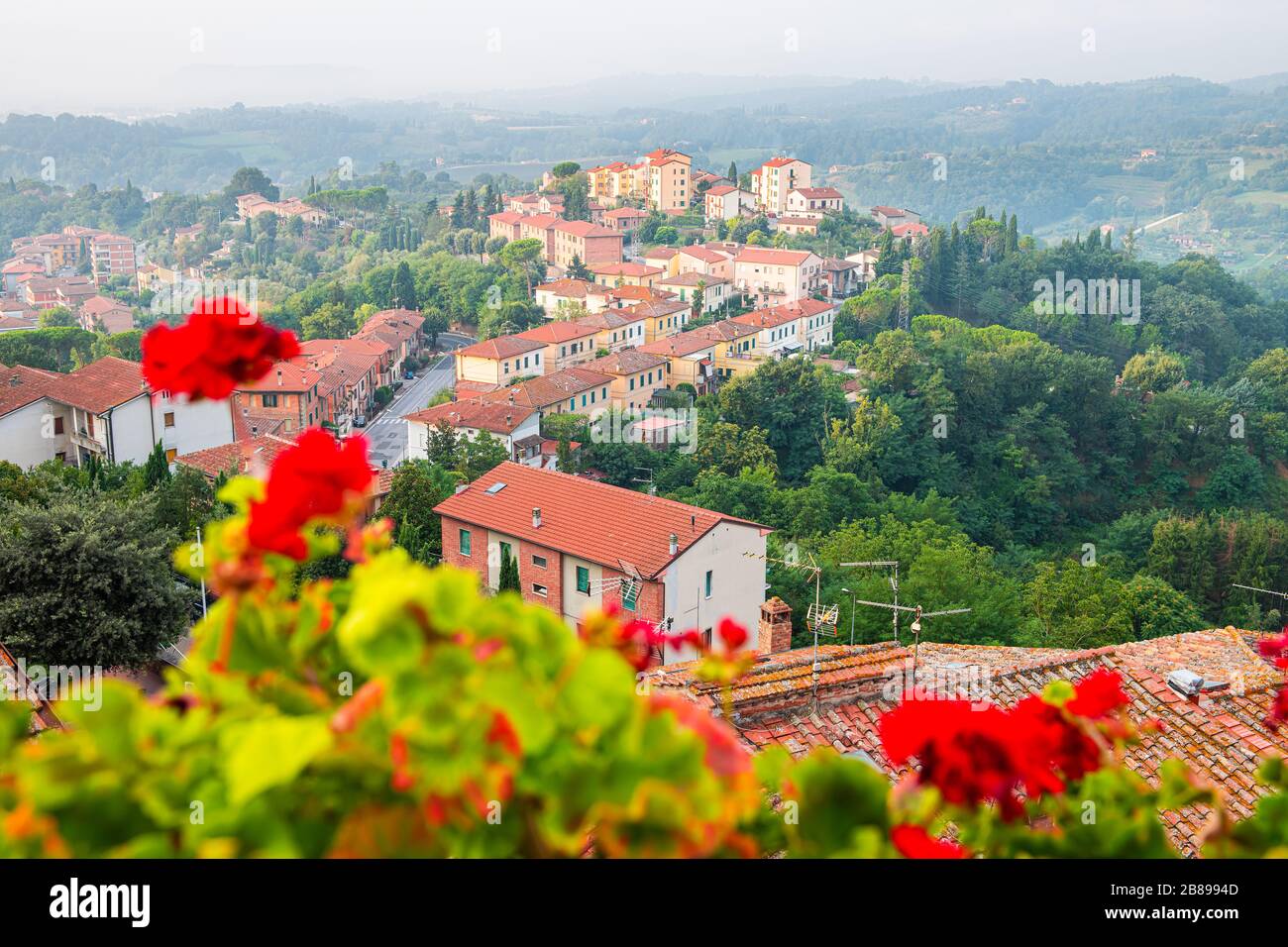 Chiusi Scalo beherbergt in der Toskana, in der Stadt Italiens Stadtbild und rote Geranienblüten im Garten im Vordergrund auf der Terrasse mit Blick auf die Landschaft Stockfoto
