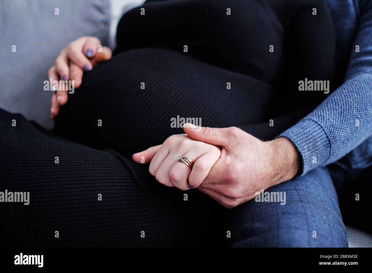 Das Paar erwartet eine Schwangerschaft in Erwartung eines Babys, das die Hände hält Stockfoto