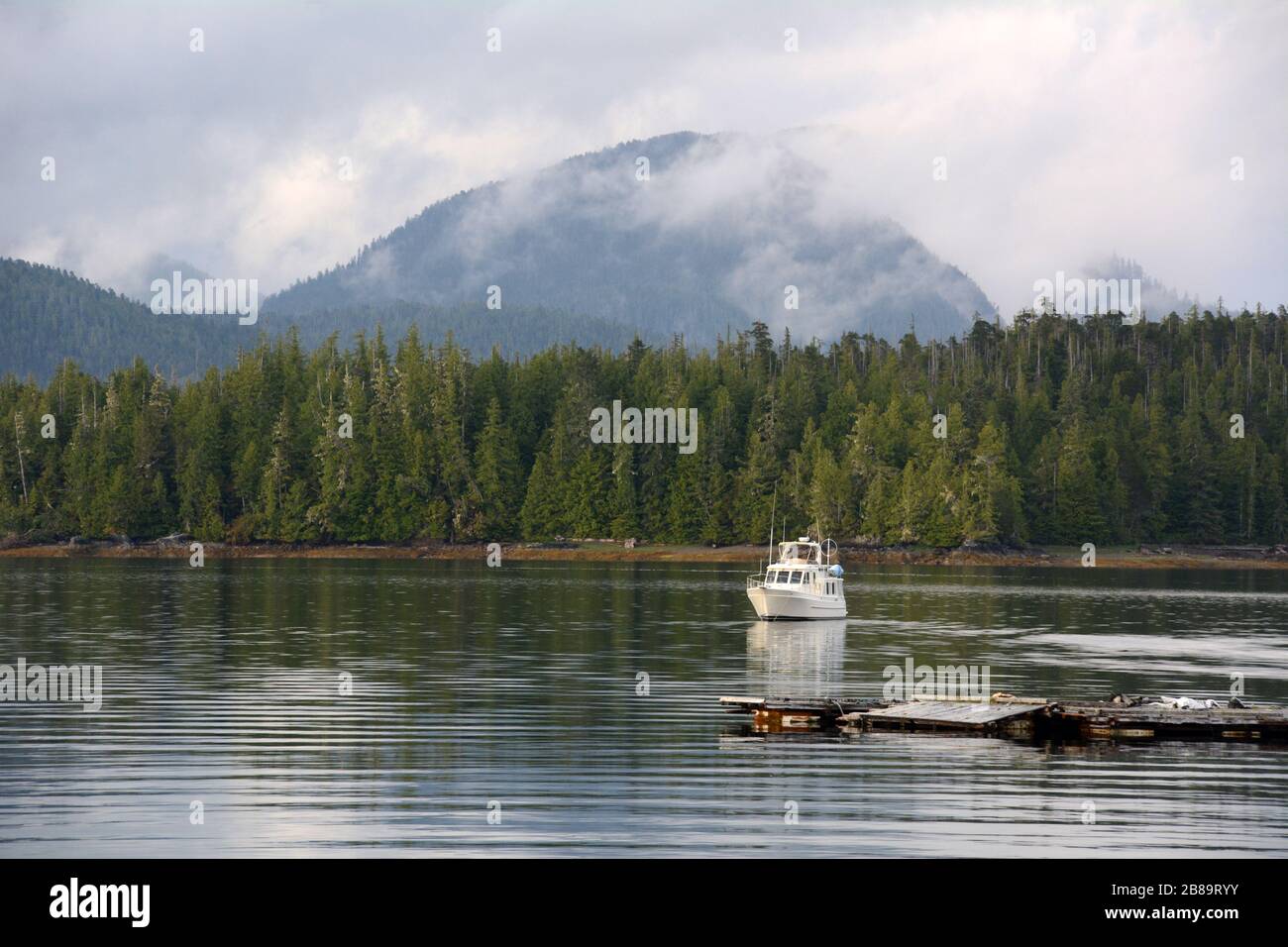 Eine kleine Yacht, die in einer Bucht vor der Gemeinde Shearwater in der Region Great Bear Rainforest an der zentralen Küste von British Columbia, Kanada, verankert ist. Stockfoto
