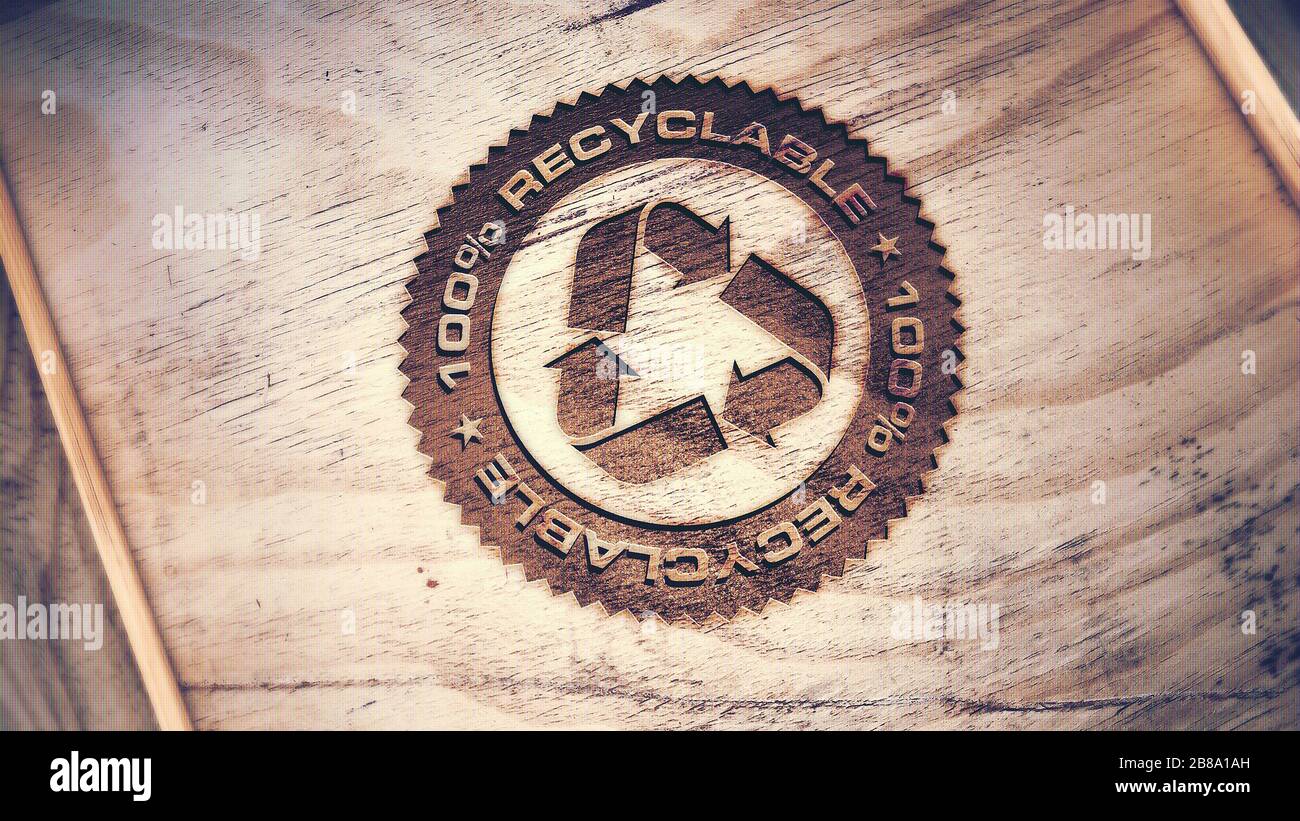 Recycling-Logo auf Holzhintergrund eingraviert. Stockfoto
