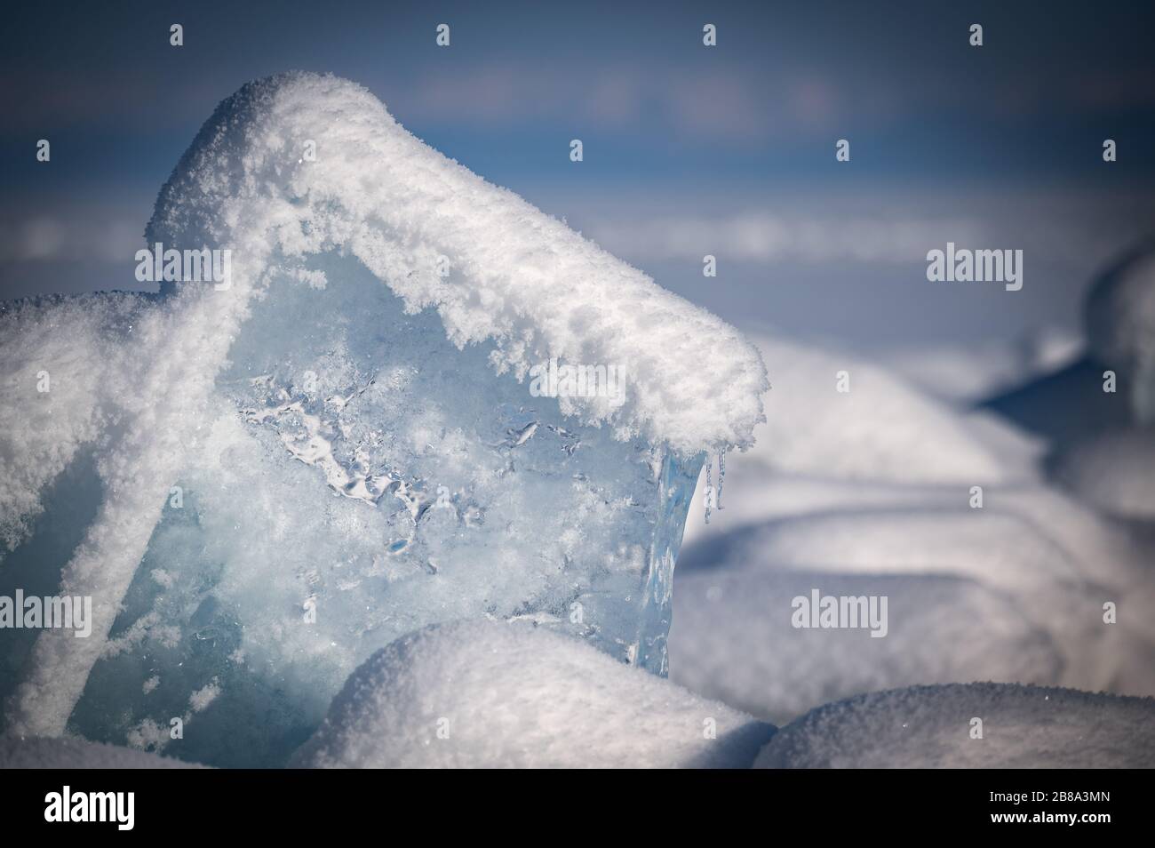 Durchsichtiges blaues Eis schwimmt an einem sonnigen Tag in Eishömmeln gegen einen blauen Himmel. Ungewöhnliche Winterlandschaft des zugefrorenen Baikalsee. Natürliche Kälte B. Stockfoto