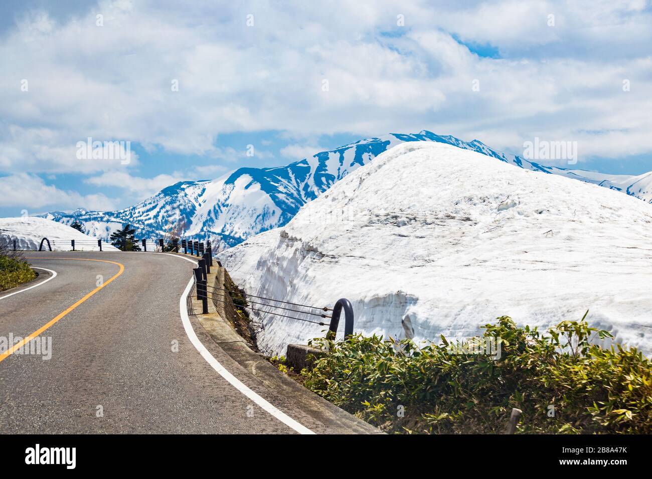 Kurvenreiche Straßen mit Schnee, die Berge und den blauen Himmel als Hintergrund in Japan Stockfoto