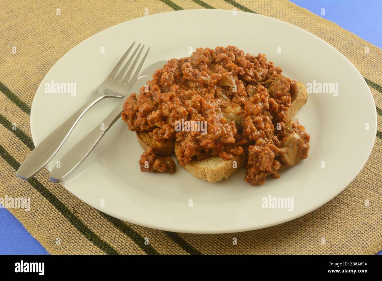 Schlampiger Joe mit Champignons aus Dosen mit Toast auf Phite Platte mit Gabel und Messer mischen Stockfoto