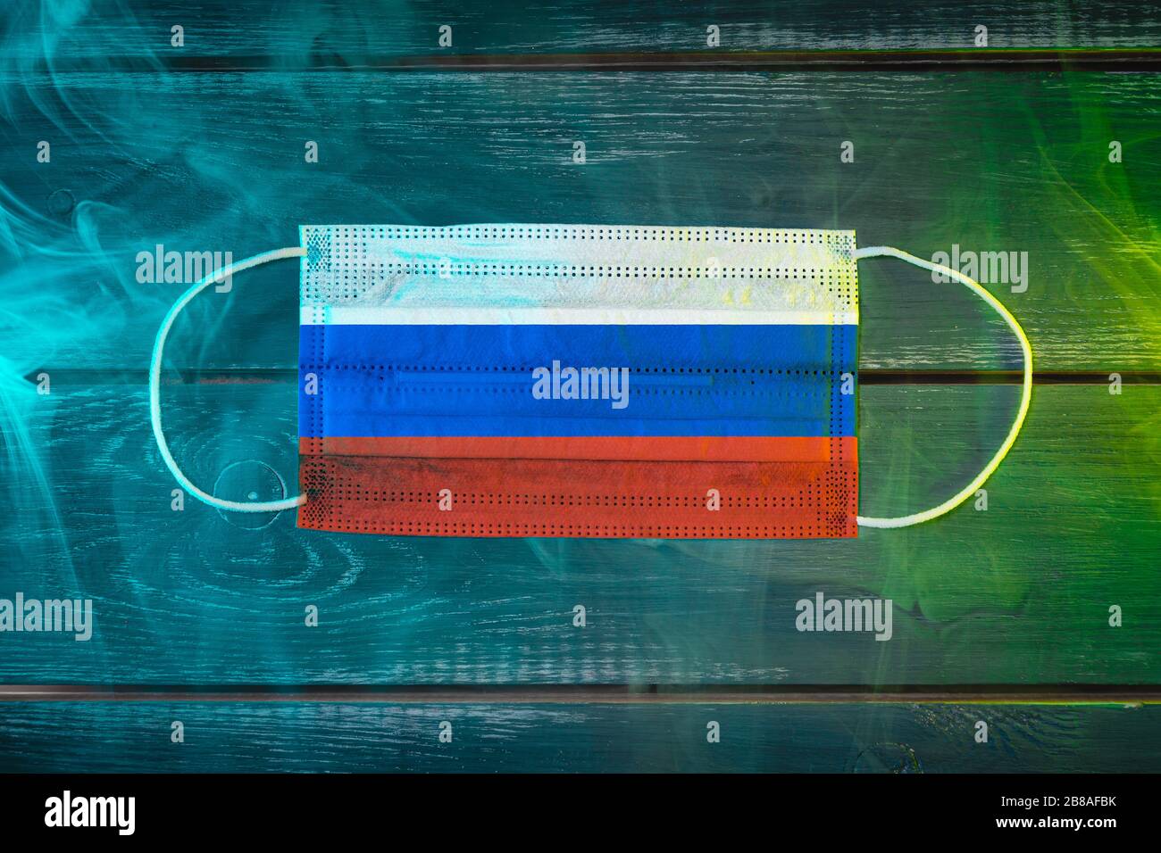 Medizinische Maske zum Schutz vor durch die Luft übertragbaren Krankheiten, in der russischen Nationalflaggen auf schwarzem Grund in blaugrünem Rauch gemalt. Medizinisches Prot Stockfoto