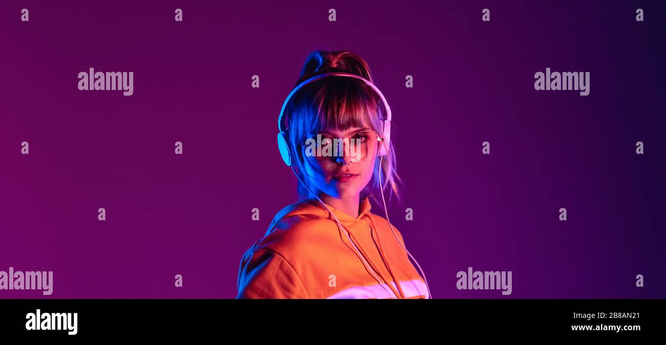 Elegante Kopfhörer für Teenager mit Brille genießen Sie Musik und Banner. Stockfoto