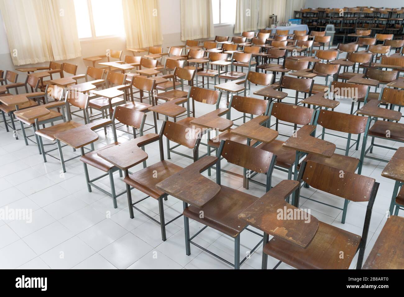 Leeres Klassenzimmer mit vielen Stühlen ohne Schüler. Leeres Klassenzimmer mit Holzstühlen in Vintage-Ton. Zurück zum Schulkonzept. Stockfoto