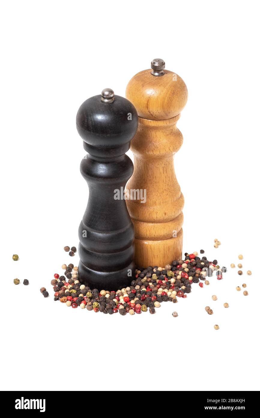Pfeffermühlen aus Holz auf Pfefferstapel mischen, schwarz, pink, grün, weiß auf weißem Grund Stockfoto